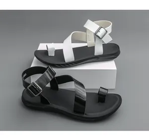 Detailansicht der Ledersandalen in Schwarz und Weiß mit Riemen und Knöchelschnallen