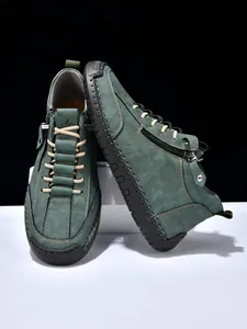 Detail of dark green suede boot featuring side zipper and reinforced rubber toe cap