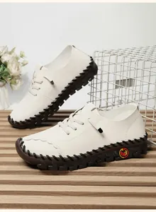 Detail of handmade white leather flat shoes with cross-stitch sole and lace-up closure