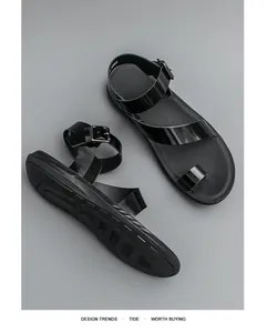Details von schwarzen Zehenring-Sandalen mit glänzenden Riemen und rutschfester Sohle