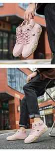 Close-up of pink high-top leather sneakers with side logo and rugged rubber outsole