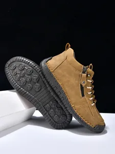 Detail of brown leather boots showing non-slip rubber soles and stitching texture