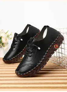 Detailed view of black leather casual shoes with hand-stitched soles and side logo