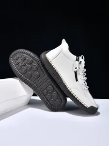Detail view of white leather high-top boots with durable side zippers and anti-slip rubber soles