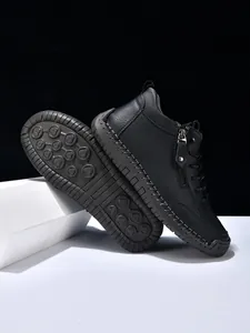 Close-up of black leather boot with side zipper, white stitching and anti-slip sole