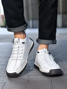 Detail of white leather boots featuring rugged hand-stitched seams and black rubber toes