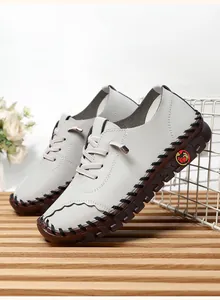 Detail of grey handmade flat shoes showing leather texture and brown gum sole stitching