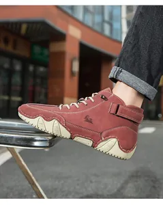 Detail of burgundy suede high-top boots with white contrast stitching and side logo