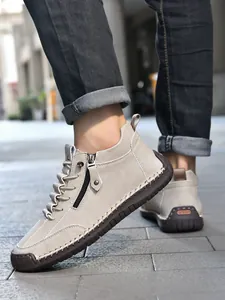 Detail of men's casual high-top boots featuring rustic hand-stitched seams and side zipper