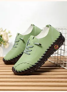 Macro detail of light green handmade leather shoe with decorative stitching and thick sole