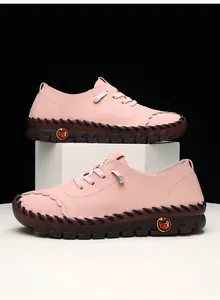 Detail of pink leather loafer featuring litchi texture and handmade stitching on sole