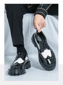 Detail von schwarz-weißen Budapester Schuhen mit goldenen Nieten und dicker Gummisohle