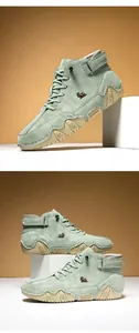 Macro shot of men's sage green high-top boots with velcro strap and wavy rubber sole