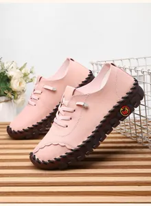 Detail of pink leather loafer featuring handmade stitching and textured lychee grain