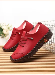 Detail of red leather casual shoes with hand-stitched thick rubber soles and litchi texture