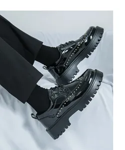 Detailsicht von schwarzen Lacklederschuhen mit Goldnieten und klobiger Plateausohle