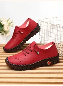 Detail of dark red leather women's shoes with hand-stitched soles and non-slip rubber