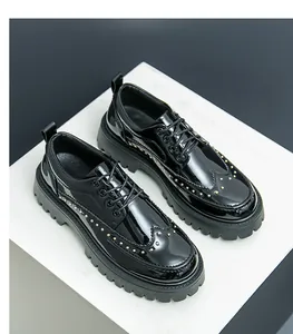 Makroansicht schwarzer Lackleder-Brogues mit Goldnieten und dicker Plateausohle