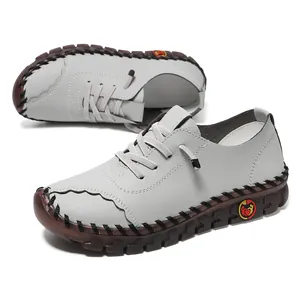 Detail of light gray leather walking shoes with hand-stitched seams and rubber soles