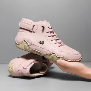 Pink high-top leather boots with animal logo and tan rubber sole for casual wear
