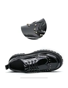 Detailaufnahme von schwarzem Lacklederschuh mit Nieten und Brogue-Flügelkappen-Muster