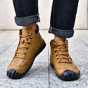 Close-up of handmade stitching and black rubber toe cap on men's tan leather casual boots