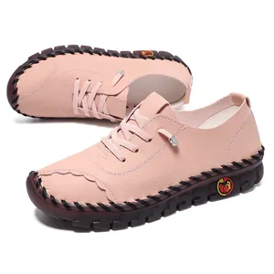 Detail of handmade light pink leather loafers with thick brown rubber soles and stitching