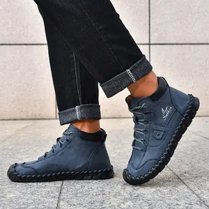Detailed view of hand-stitched seams and blue suede texture on men's high-top casual boots