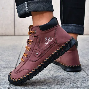 Detail of red-brown leather boots showing hand-stitched soles and side logo