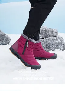 Outdoor view of pink winter snow boots with faux fur collar and side zipper on real snow