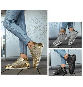 Dettaglio degli stivali alti glitterati in oro, argento e nero con paillettes lucide