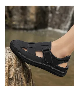 Detail of men's leather sandal showing stitching and durable rubber sole in nature