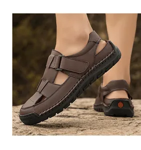 Detail of men's leather sandals with hand-stitched seams and velcro straps outdoors