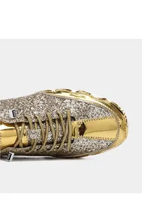 Detailansicht goldener Pailletten-Sneaker mit Glitzertextur und spiegelnder Leder-Optik