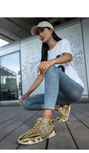 Dettaglio di sneaker alte con paillettes dorate e suole in gomma bianca a onde
