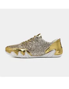 Makroaufnahme der goldenen Glitzertextur und Metallic-Lederpaneele an den Sneakern
