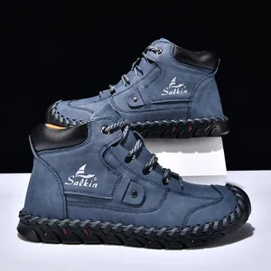 Macro view of blue suede boots featuring handmade stitching and Salkin brand logo details