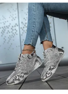 Dettaglio macro degli stivali argento con paillettes, pelle metallizzata e suola platform