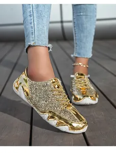 Detailaufnahme goldener Pailletten-Sneaker mit Wellensohle und blauen Jeans