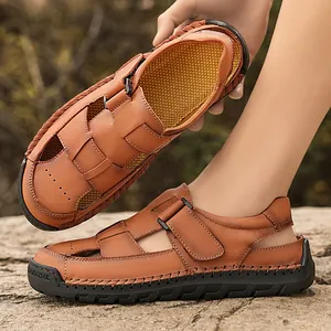 Men's brown leather sandals with hand-stitched rubber soles on a natural rock background