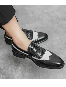 Λεπτομερής λήψη από brogue ραφές και κρόσσια kiltie σε ασπρόμαυρα δερμάτινα παπούτσια