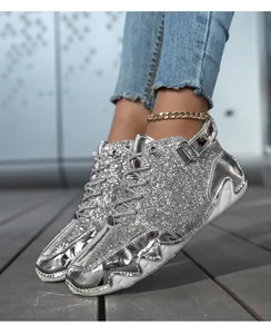 Dettaglio di sneaker alta con paillettes argento, inserti metallici e suola platform bianca