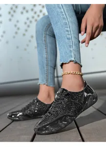 Tragefoto schwarzer Glitzer-Sneaker mit dicken Wellensohlen und Pailletten-Details