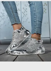 Dettaglio ravvicinato di sneakers alte glitterate argento con lacci e cinturino in velcro