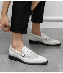 Λεπτομέρεια από λευκά δερμάτινα loafers με σχέδια brogue και μαύρες χοντρές σόλες