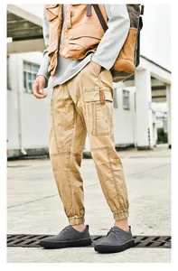 Vista laterale dei pantaloni cargo kaki con ampie tasche e dettagli etichetta XVH
