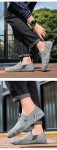 Detail of grey suede loafers featuring wave-pattern rubber sole and animal motif