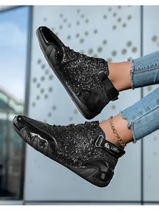 Dettaglio di sneaker alte glitterate con paillettes nere e cinturino a strappo LDECK
