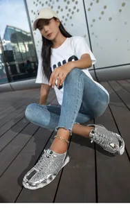 Modische silberne Pailletten-Sneaker mit dicker Sohle in einer Outdoor-Umgebung