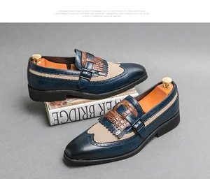 Λεπτομέρεια από σκάλισμα wingtip brogue και αγκράφα monk strap σε μπλε-μπεζ δερμάτινα